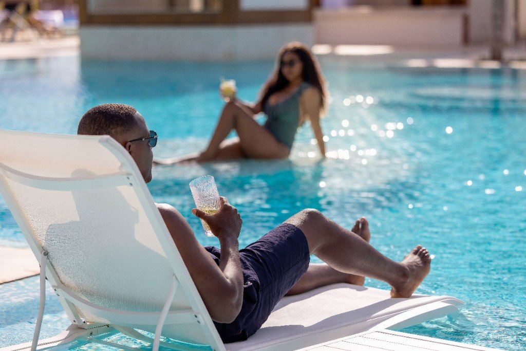 Guests relaxing poolside with drinks at Moon Palace The Grand Punta Cana