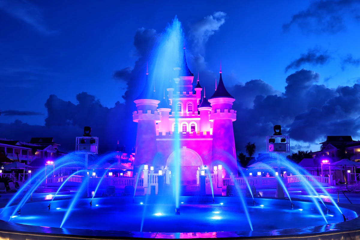 The castle at Bahia Principe Fantasia is lit up at night with a large water fountain in front of it. Its a very whimsical and magical sight.